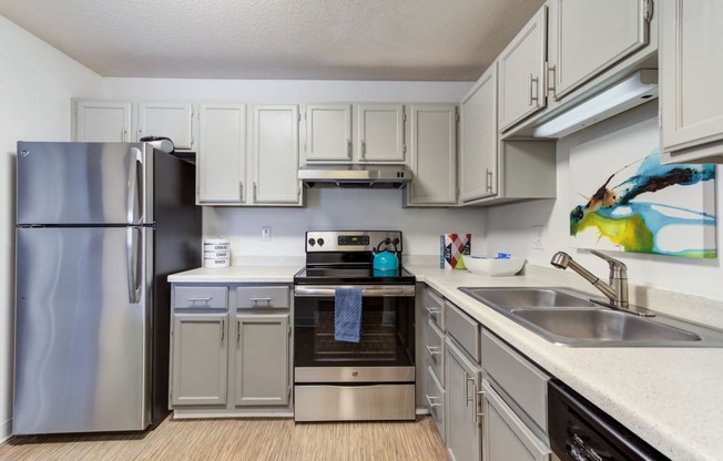 a kitchen with white cabinets and stainless steel appliances