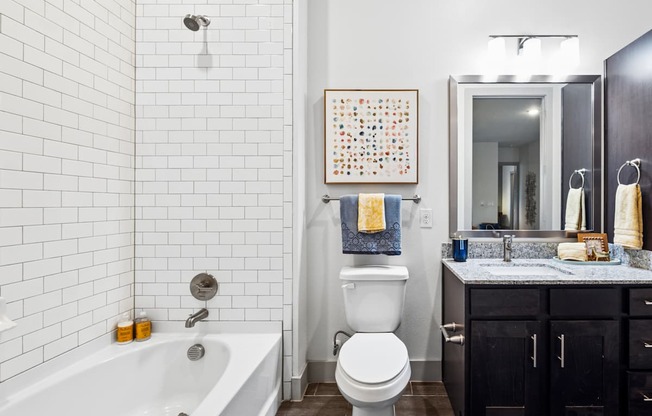A bathroom with a white tub, toilet, and sink.