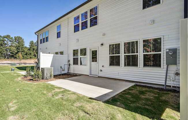 the outside of a white house with a concrete driveway