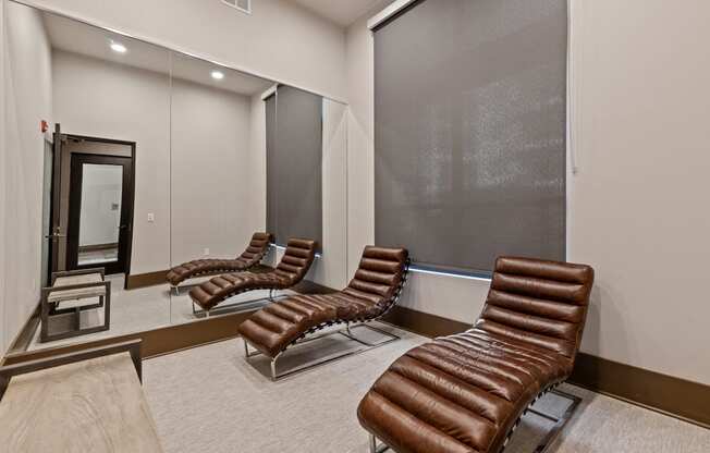 a private screening room with leather chairs in front of a mirror