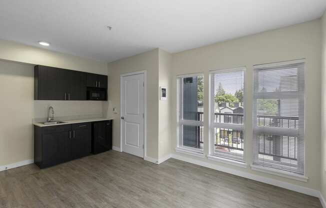 a kitchen and living room with plank flooring and oversized windows in an apartment at Sedona Apartments, Seattle, Washington