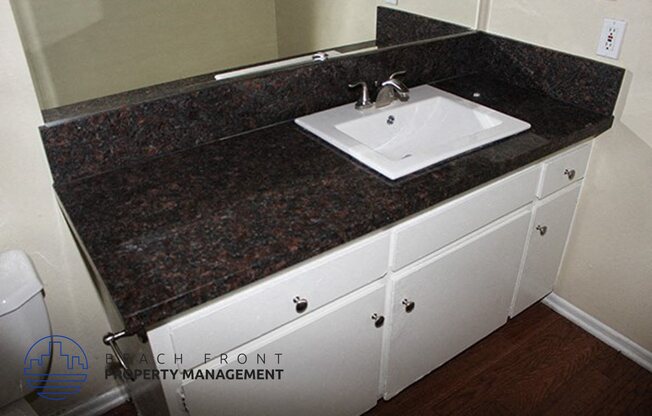 a bathroom with a sink and a granite counter top