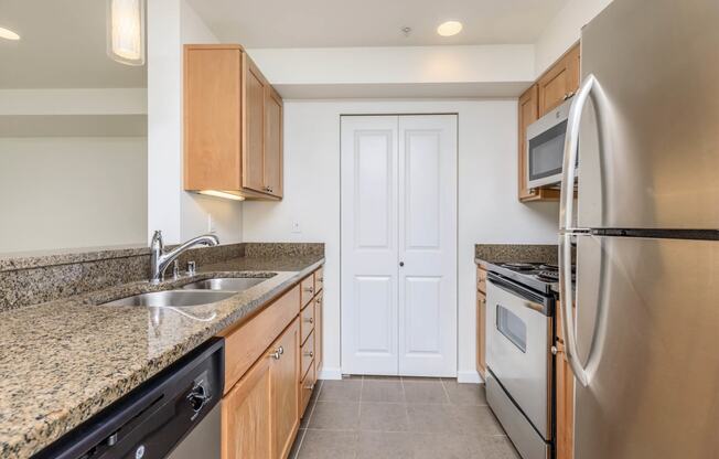 a kitchen with granite counter tops and stainless steel appliances at Delano, Redmond