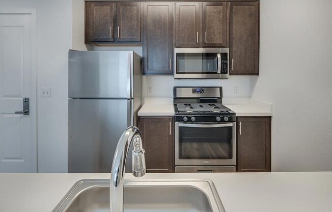 a kitchen with a sink stove refrigerator and microwave