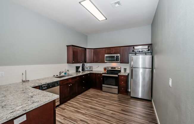 a kitchen with wood floors and stainless steel appliances