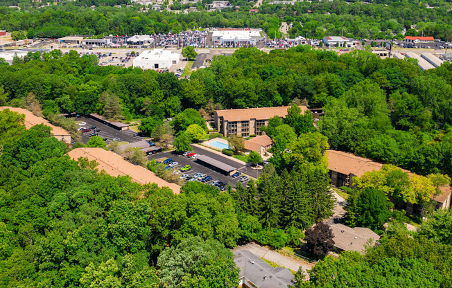 A large building surrounded by trees is seen from above.