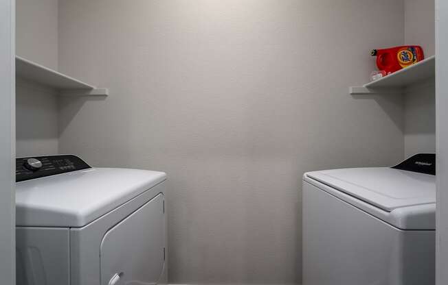 a small laundry room with two washes and a dryer