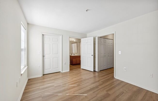 an empty living room with white walls and wood floors