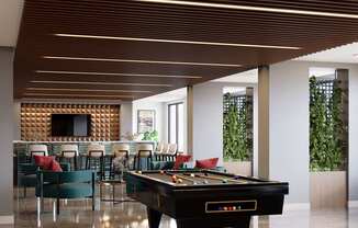 A pool table is in the middle of a room with a tv and chairs at Refinery at Pointe17 Apartments, Phoenix