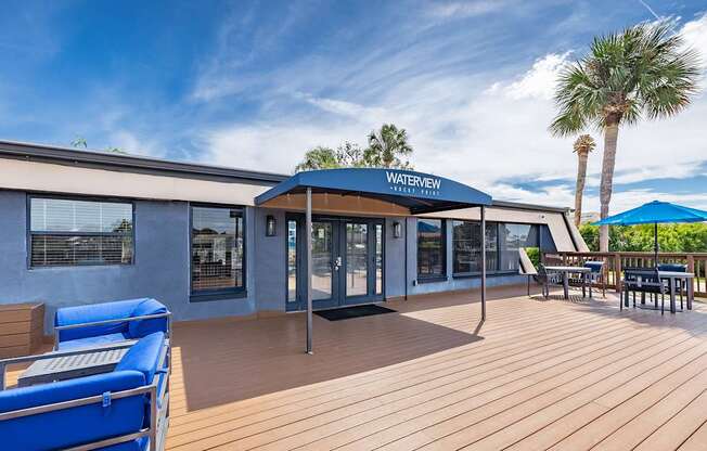 A wooden deck with a blue canopy and a pool table.