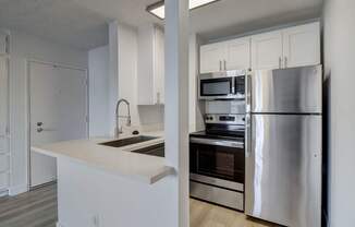 A modern kitchen with stainless steel appliances and white cabinetry.