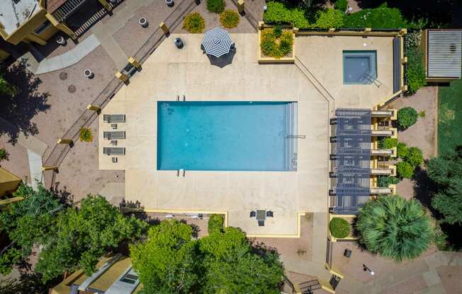 arial view of a swimming pool in a backyard with trees