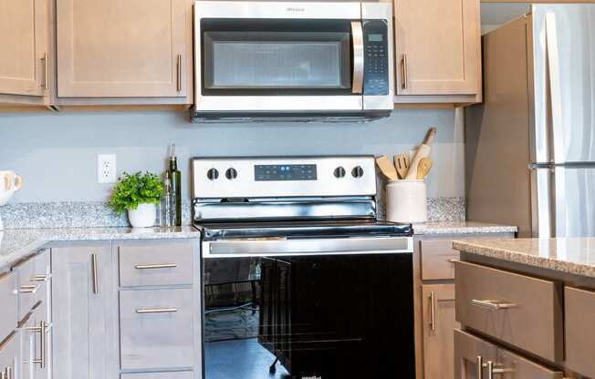 a modern kitchen with stainless steel appliances and white cabinets