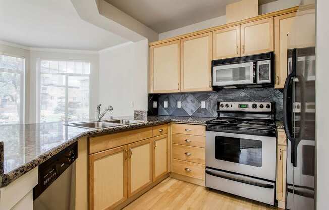 a kitchen with stainless steel appliances and wooden cabinets  at Delano, Redmond Washington