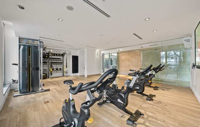 two treadmills in a gym with a glass wall and a yoga studio