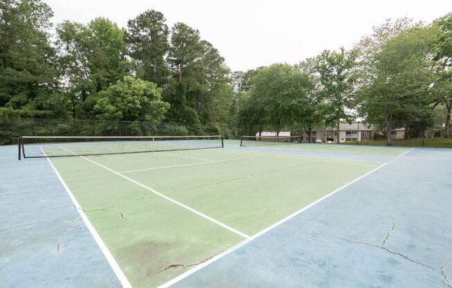 a tennis court at the whispering winds apartments in pearland, tx