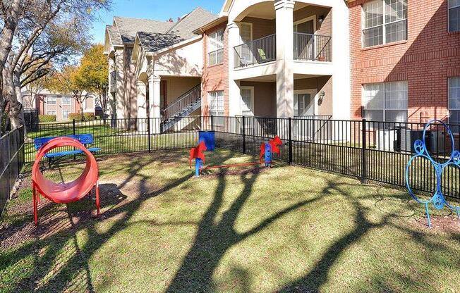 Plano Apartments for Rent - Carrington Park - Outside Pet Park with Jumping Hoops, Tunnel, and More Play Equipment