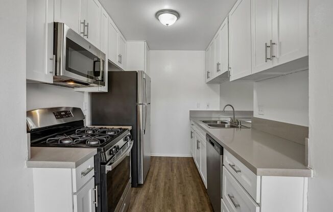 A kitchen with white cabinets and stainless steel appliances