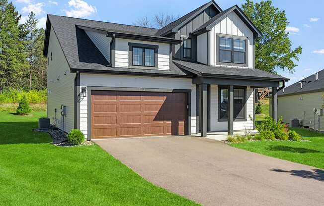 a house with a brown garage door in front of it