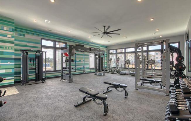 the gym in the home has plenty of equipment and windows