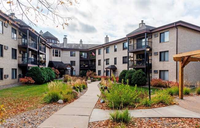 an exterior view of an apartment building with a sidewalk