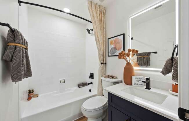 a bathroom with a white tub next to a toilet and a sink