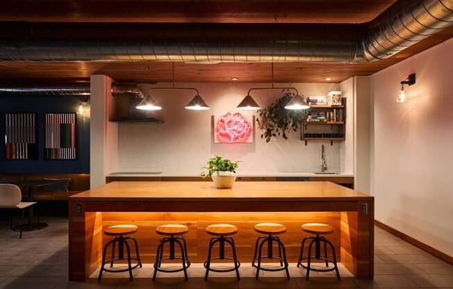 A bar with a wooden counter and four stools.
