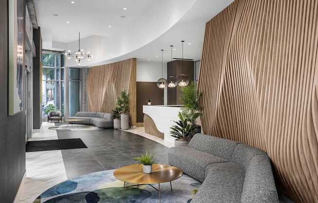A modern living room with a curved wooden wall and a grey sofa.