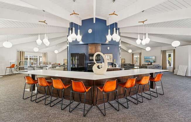 A large conference room with a long table and orange chairs.