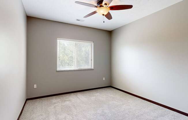 a bedroom with a ceiling fan and a window