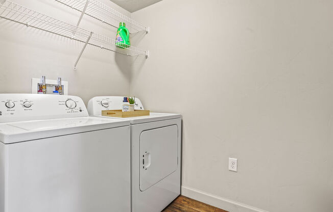 the laundry room has a washer and dryer and a rack on the wall