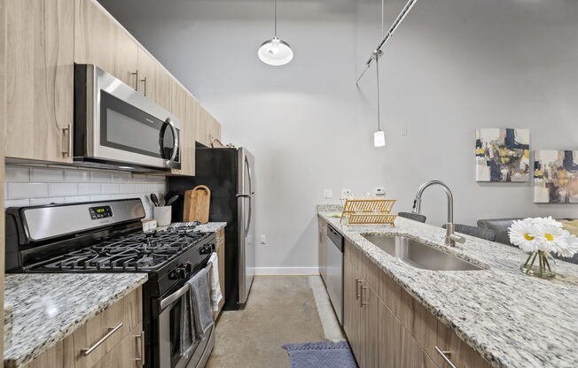 kitchen with granite countertops and stainless steel appliances at the flats at big tex apartments in san