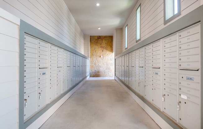 a row of lockers in a long room with a stone wall