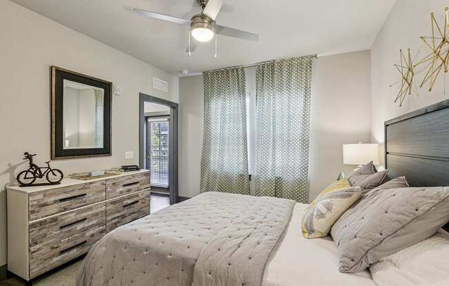 Cozy bedroom with natural light, ceiling fan, and neutral decor at Lotus at Starkey Ranch in Odessa, Florida.