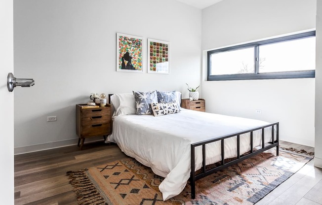 Cozy and inviting bedroom at L Logan Square Apartments, featuring a comfortable bed, soothing decor, and a relaxing ambiance, providing the perfect retreat for rest and rejuvenation.