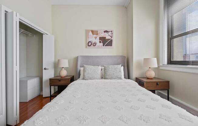 A bedroom with a large bed and two nightstands with lamps.