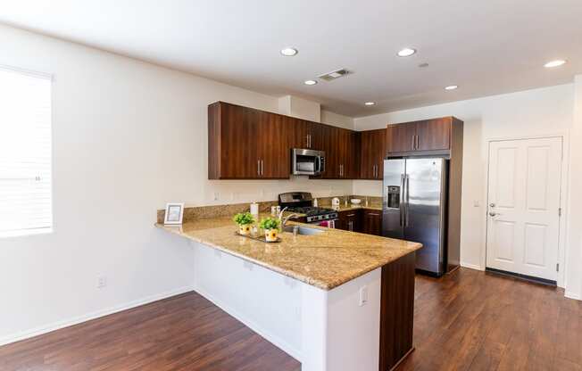 a kitchen with a granite counter top and a stainless steel refrigerator at The Vines at Riverpark, LLC, California, 93036