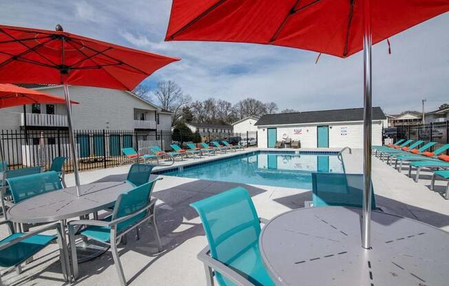 a swimming pool with tables and chairs and umbrellas at Cleo Apartments, Athens, 35611