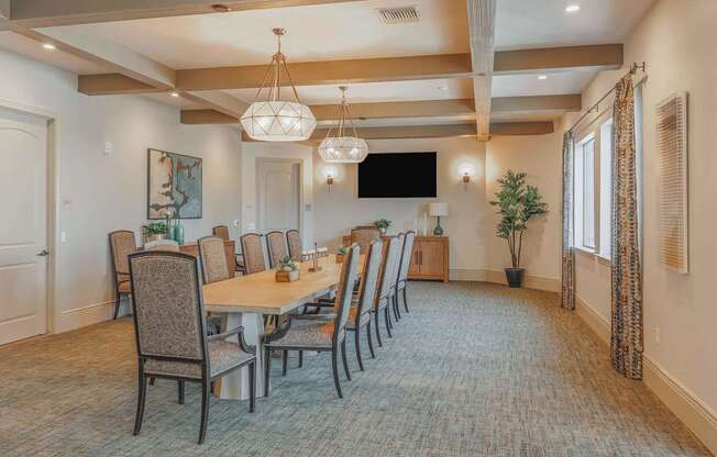 A large dining room with a long table and chairs.