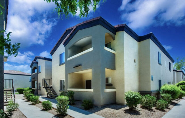 a row of white houses with a blue sky in the background at Villas on Bell, Arizona, 85053