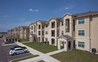A car is parked in a parking lot in front of a building.