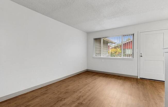 Empty room with wooden floor and white walls.