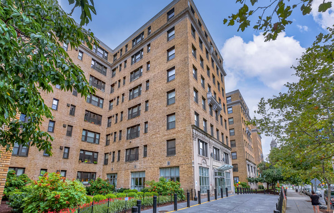 a large brick building with a sidewalk in front of it