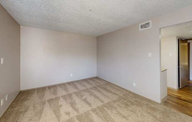 A room with a carpeted floor and a door on the right.