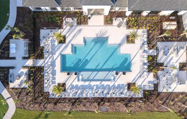 An aerial view of a house with a swimming pool in the backyard.