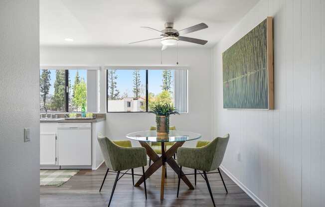 a dining room with a table and chairs and a ceiling fan