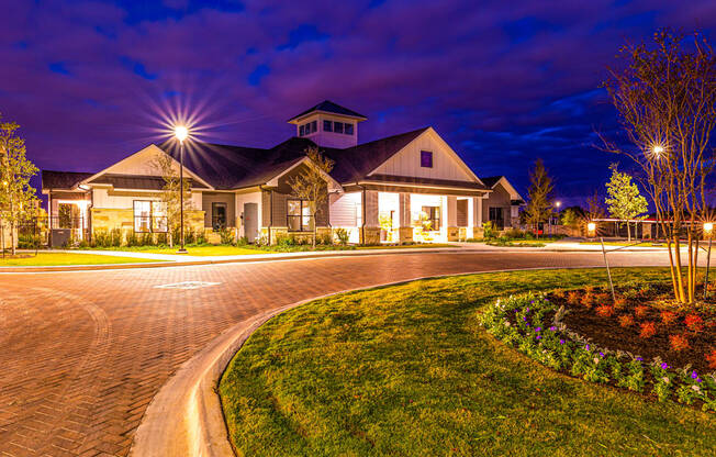 House with a driveway and a street at night at The Parker Austin, Pflugerville, TX