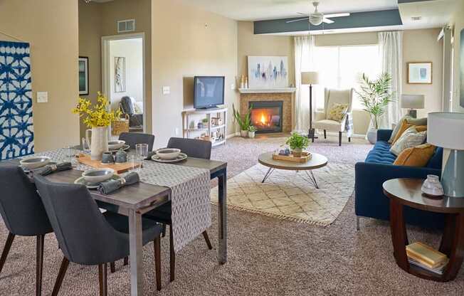 a living room with a table and chairs and a fireplace at The Winhall of Williams Pointe Apartments, IOWA, 50263