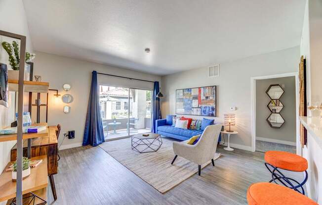 A living room with a blue couch and a white chair.
