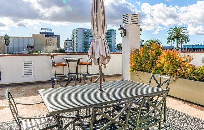 Open air rooftop patio with gas firepit, BBQs, several seating locations, and cable television.